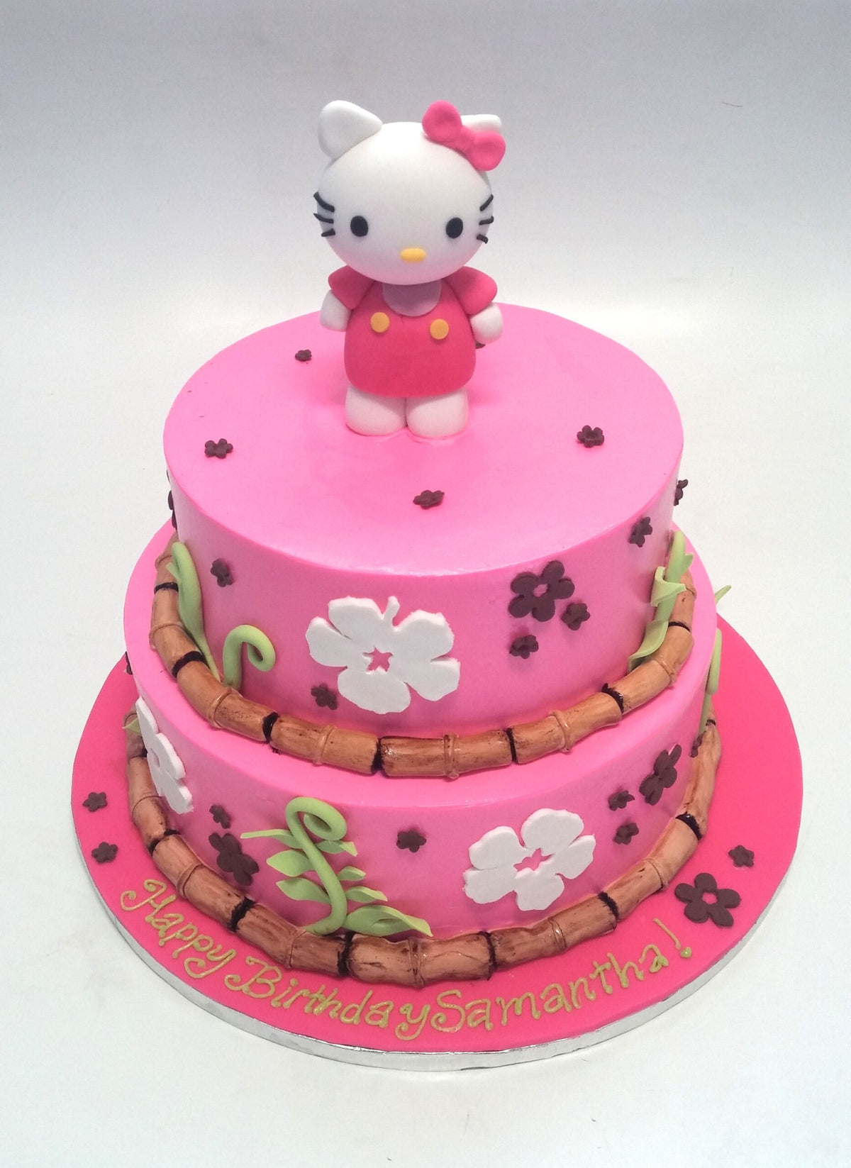 Two-tier cake decorated with a tropical Hello Kitty theme
