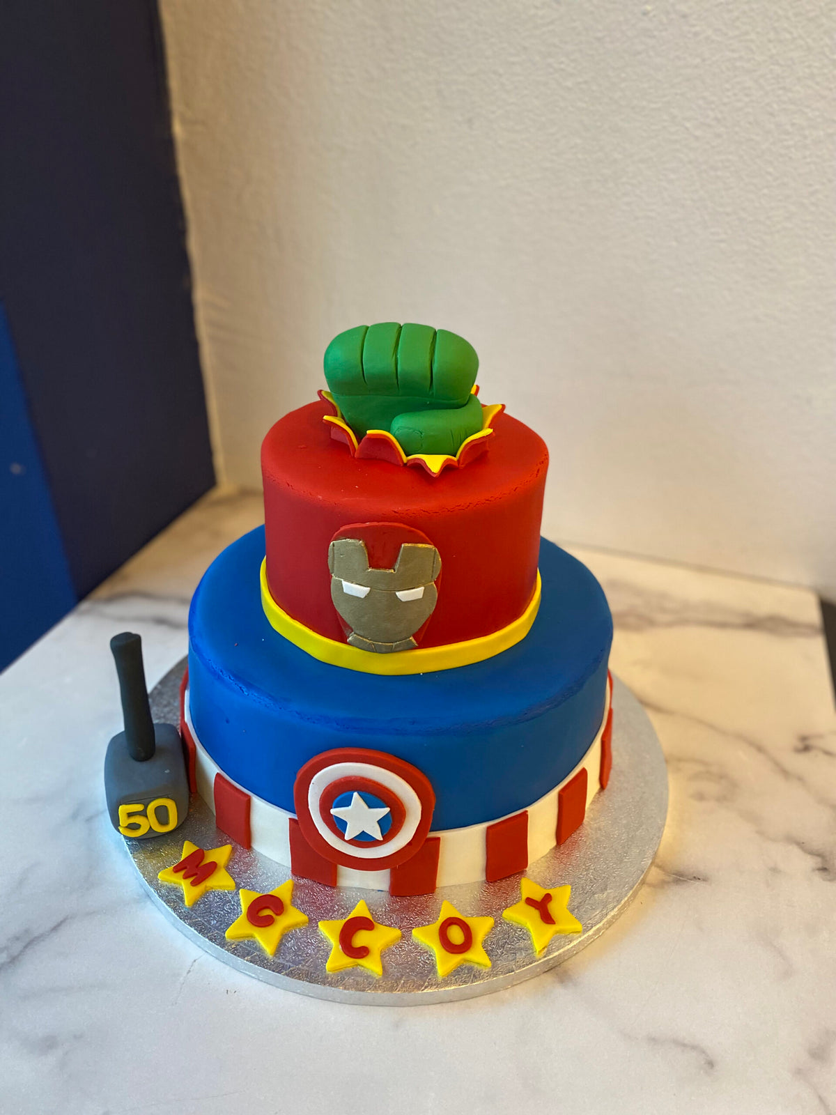 Two-tier cake decorated with a Marvel superhero theme