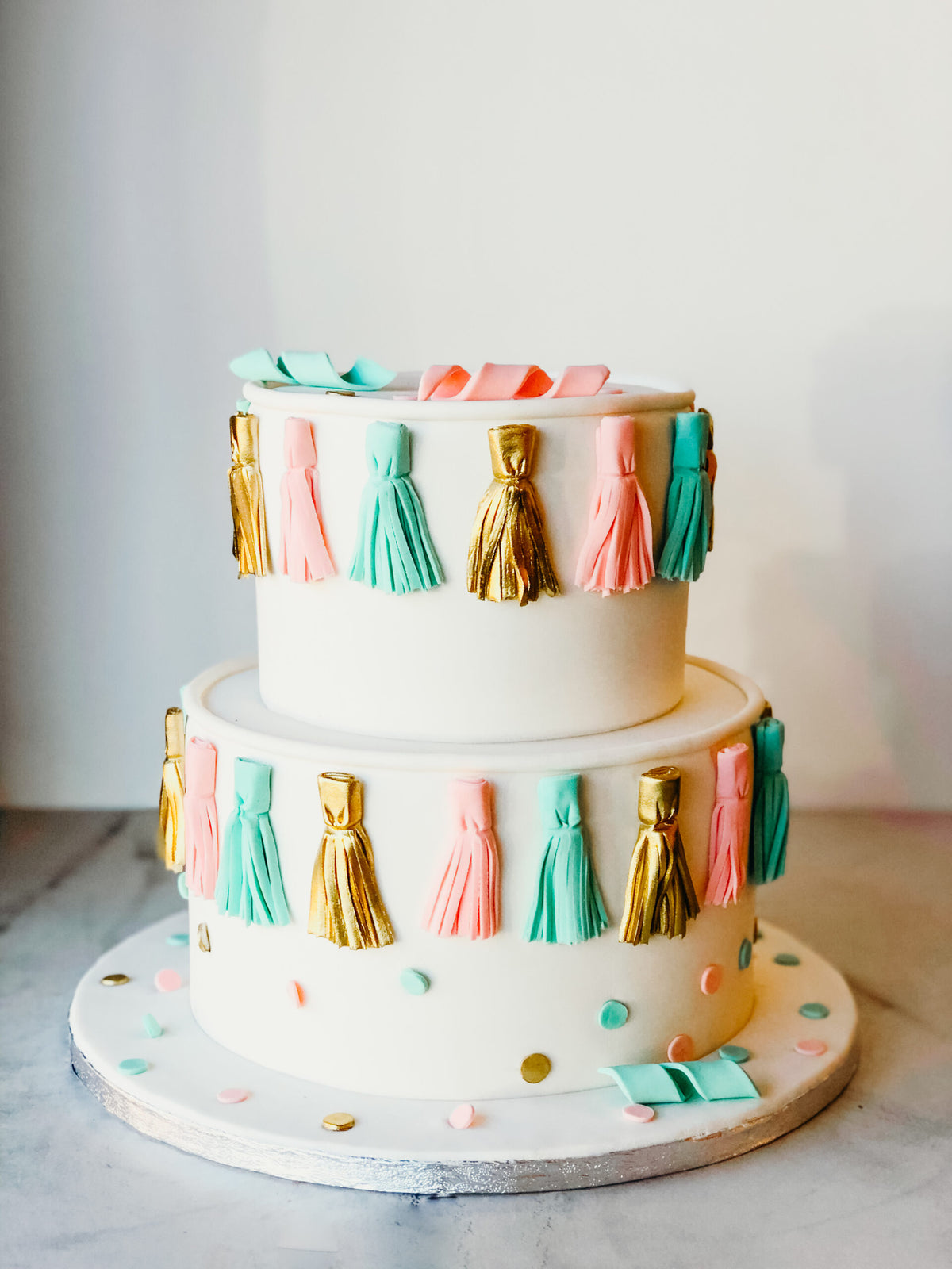 Two-tier cake decorated with fondant tassels