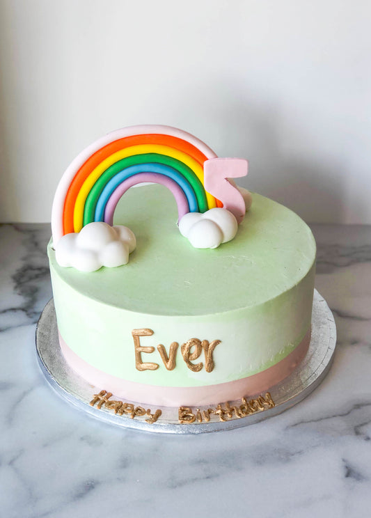 3D sculpted rainbow-shaped cake with colorful fondant detailing