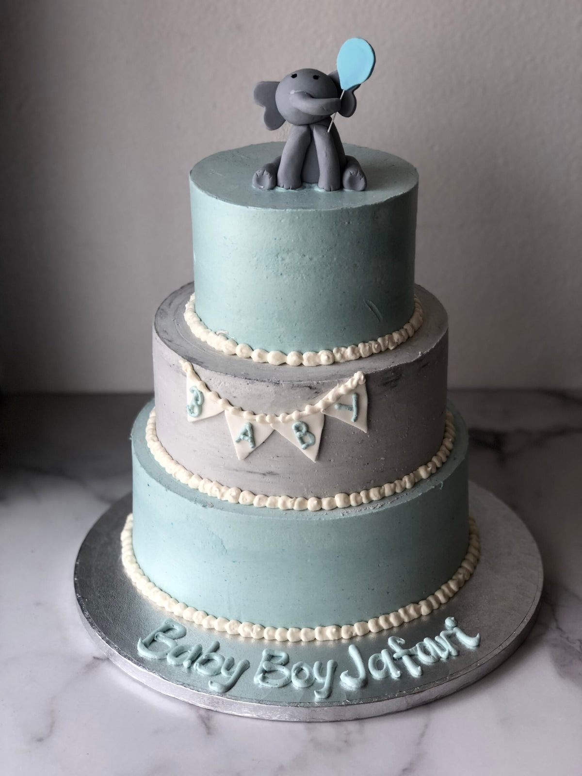 Three-tier baby shower cake decorated with an elephant design