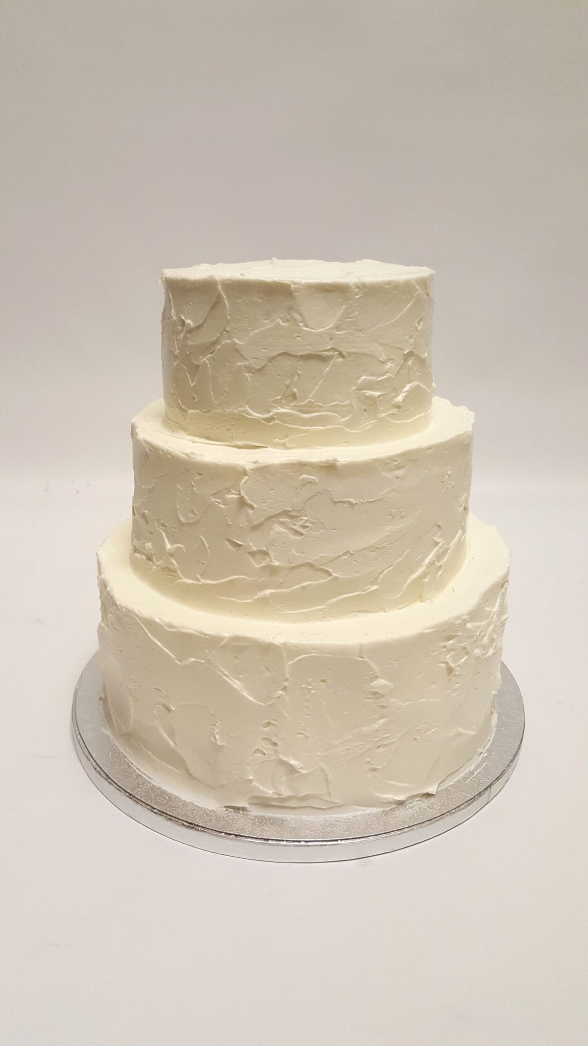 Three-tier wedding cake with hand-piped textured buttercream finish