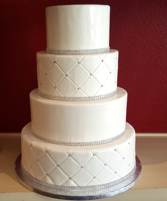 Four-tier wedding cake with quilted fondant detailing on every tier