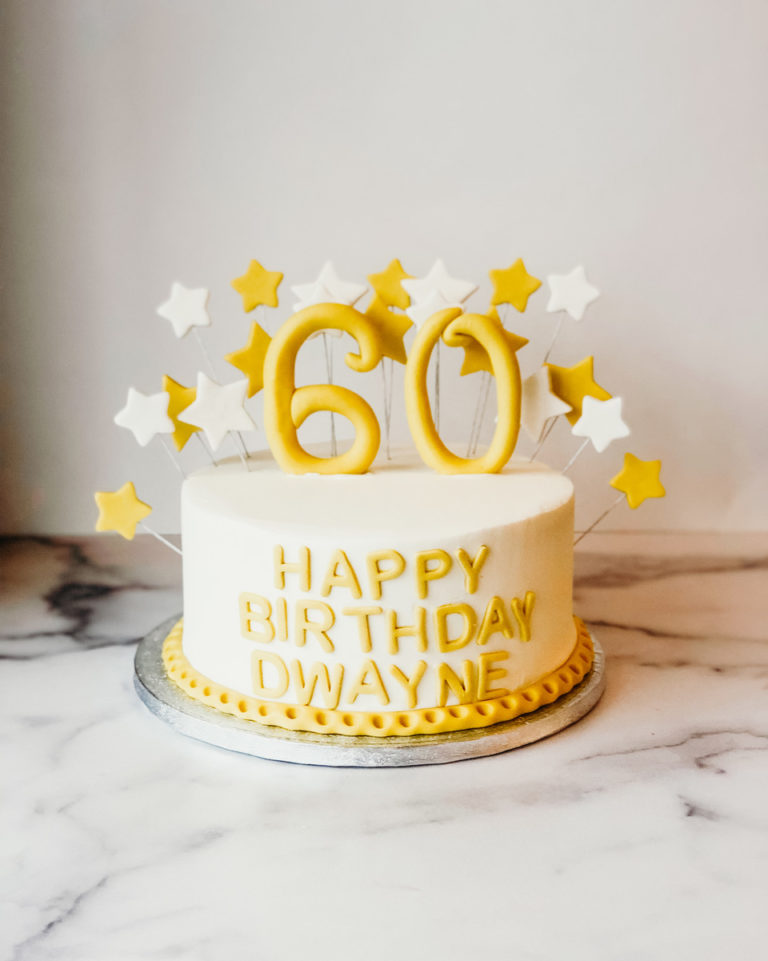 Birthday cake decorated with fondant stars and a custom age number topper