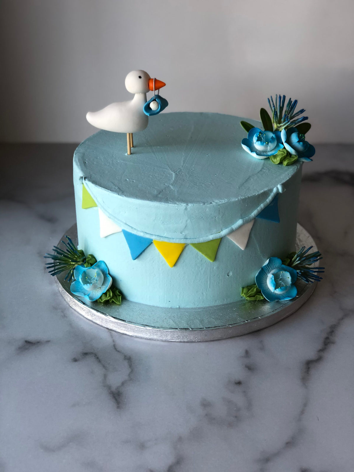 Baby shower cake decorated with a blue fondant stork
