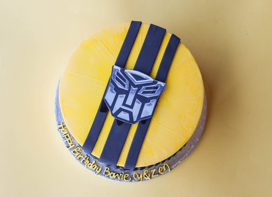 Birthday cake shaped and decorated like the Transformers character Bumblebee