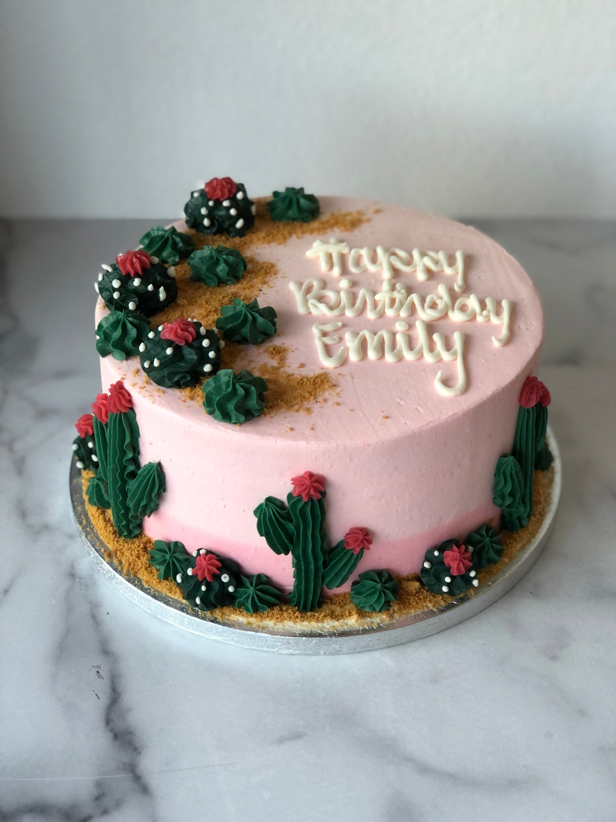 Birthday cake decorated with fondant cacti and desert-themed details