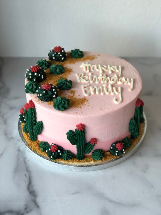 Birthday cake decorated with fondant cacti and desert-themed details