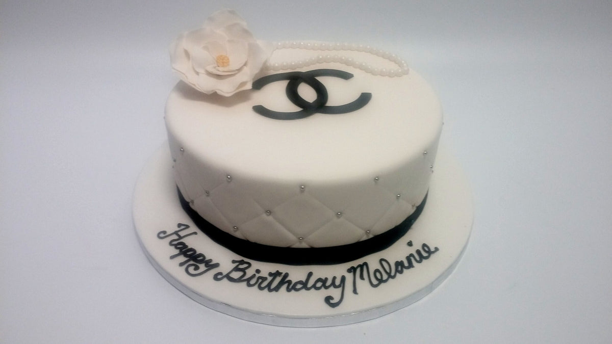 Cake decorated in a Chanel-inspired black, white, and gold design