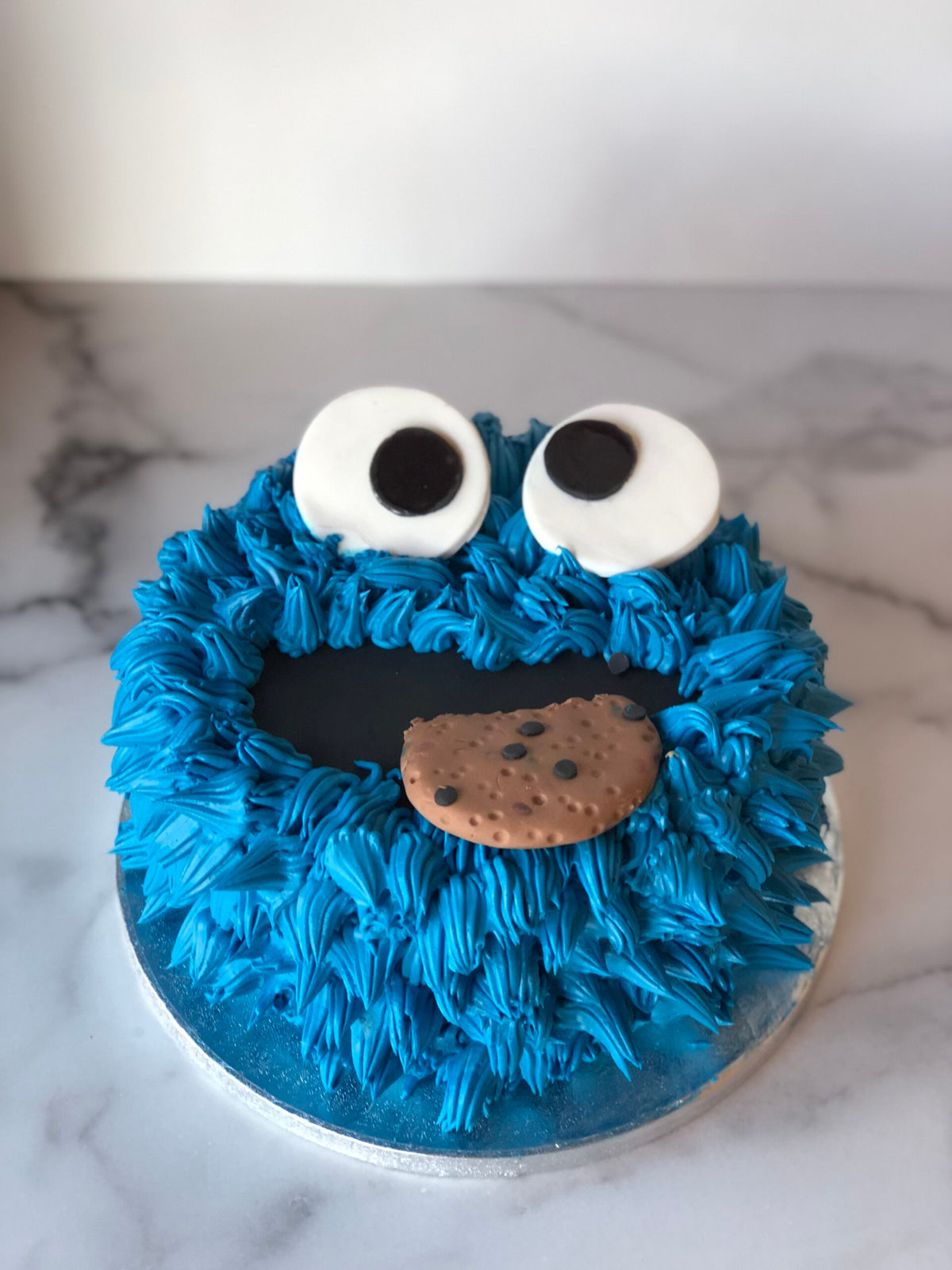 Sesame Street Cookie Monster birthday cake with a sculpted character topper