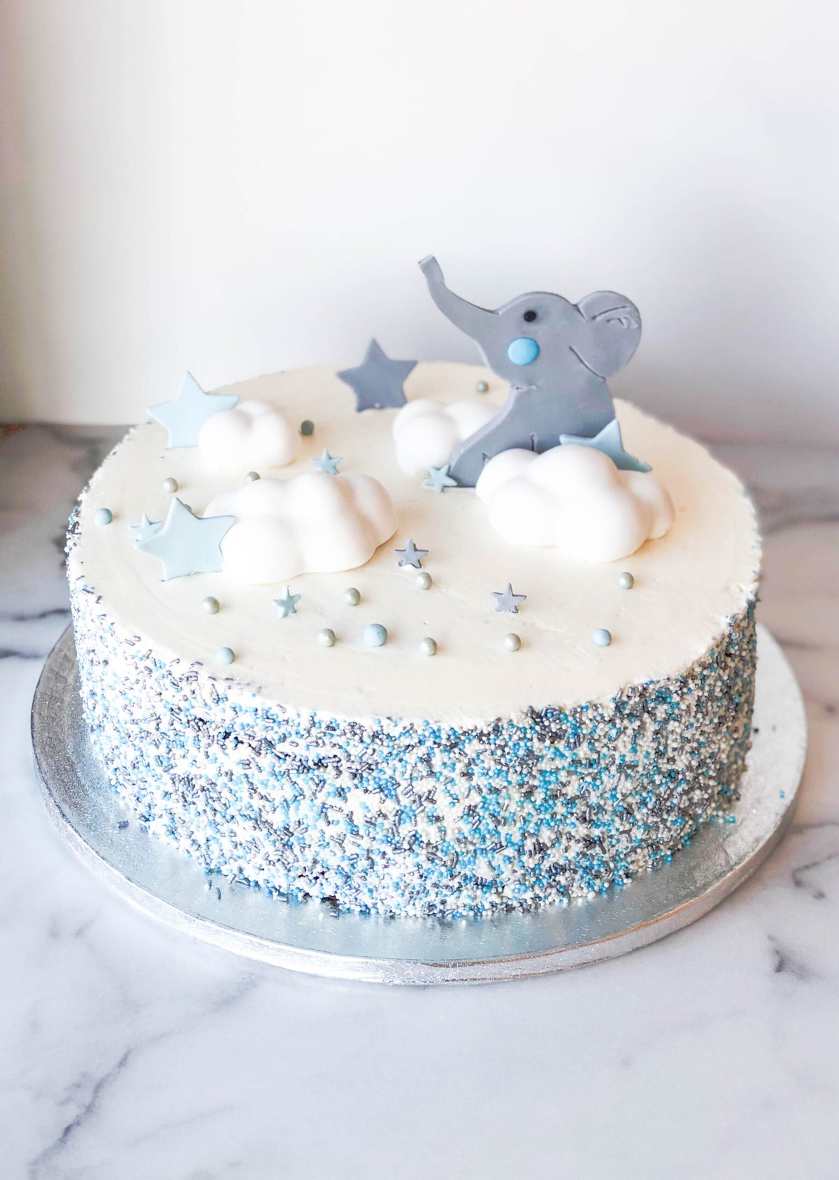 Baby shower cake decorated with an elephant in the clouds design