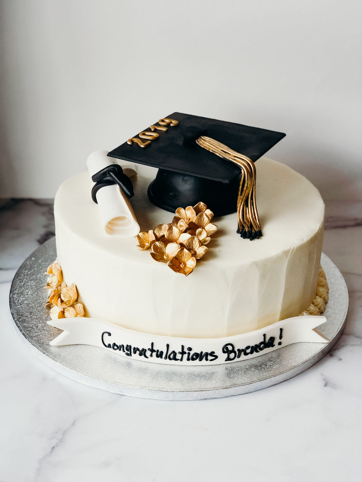 Graduation cake decorated with gold floral accents