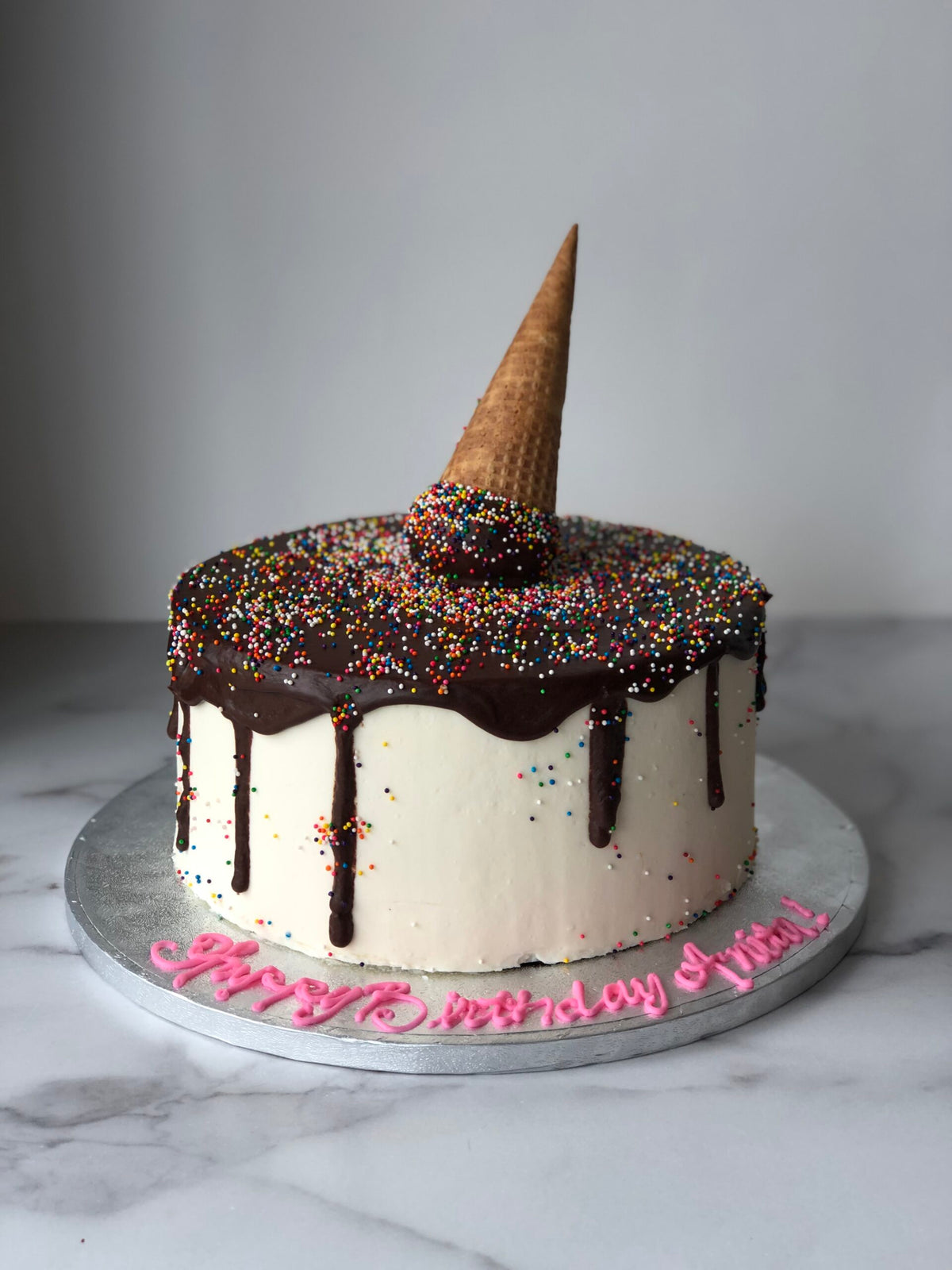 Cake decorated to look like a sprinkle-covered ice cream scoop