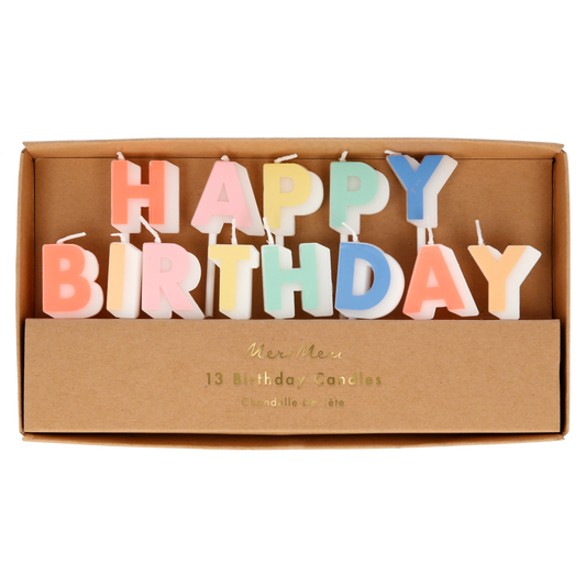 A set of 13 colorful letter candles spelling 'HAPPY BIRTHDAY' displayed inside a brown cardboard gift box. The letters are in pastel shades of pink, orange, yellow, green, blue, and purple, with white wicks.