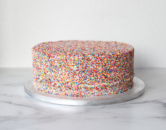Classic birthday cake covered in colorful rainbow sprinkles