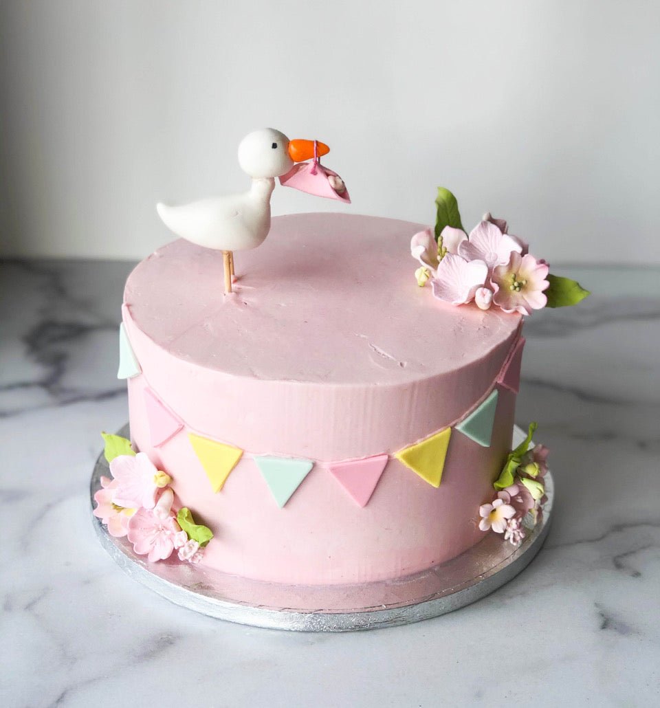 Baby shower cake decorated with a pink fondant stork