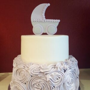 Two-tier baby shower cake decorated with a baby stroller design