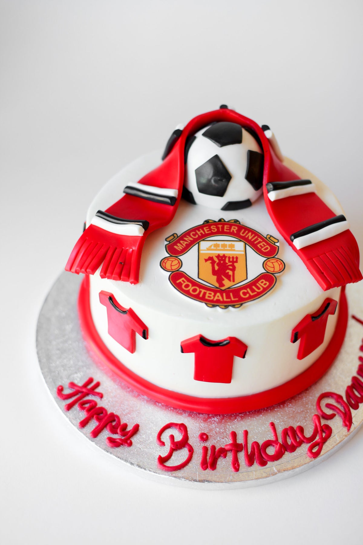 Manchester United-themed birthday cake with team colors and soccer ball details