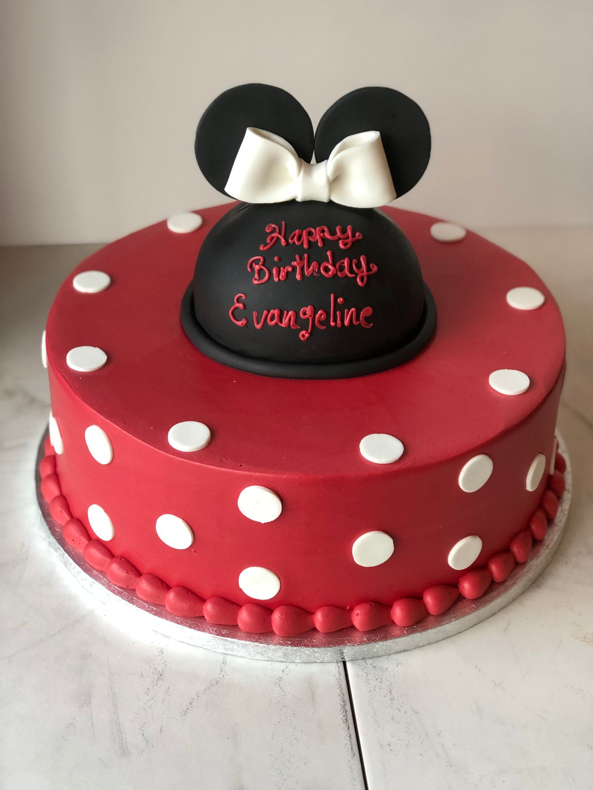 Two-tier cake decorated with a Minnie Mouse theme