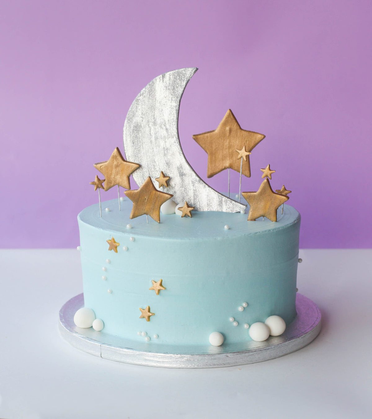 Baby shower cake decorated with a fondant moon and stars in soft pastel tones