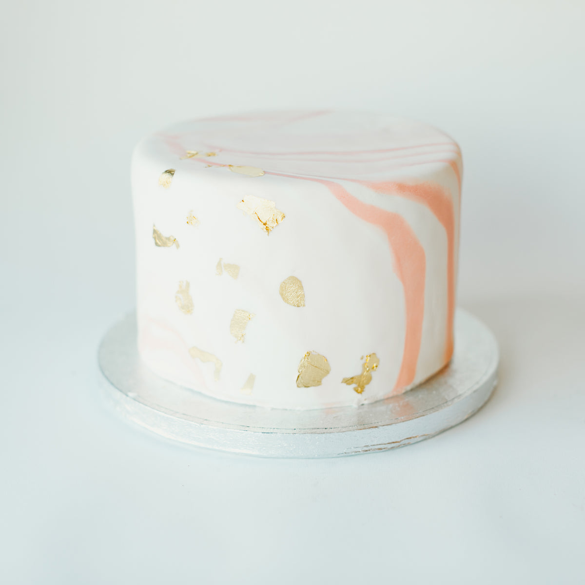 Cake decorated with a pink and gold marble design