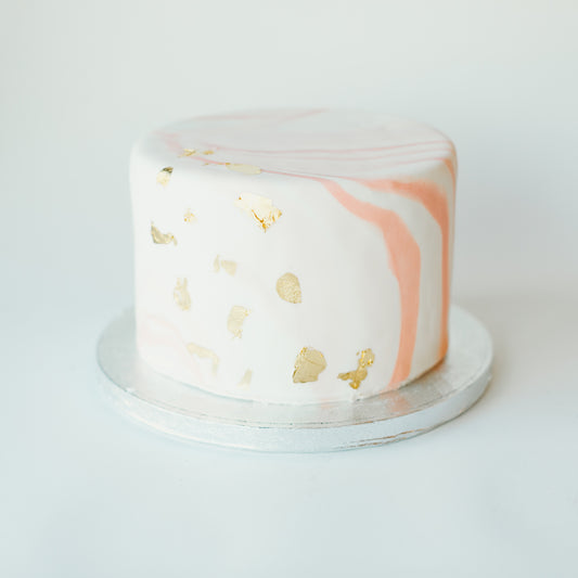 Cake decorated with a pink and gold marble design
