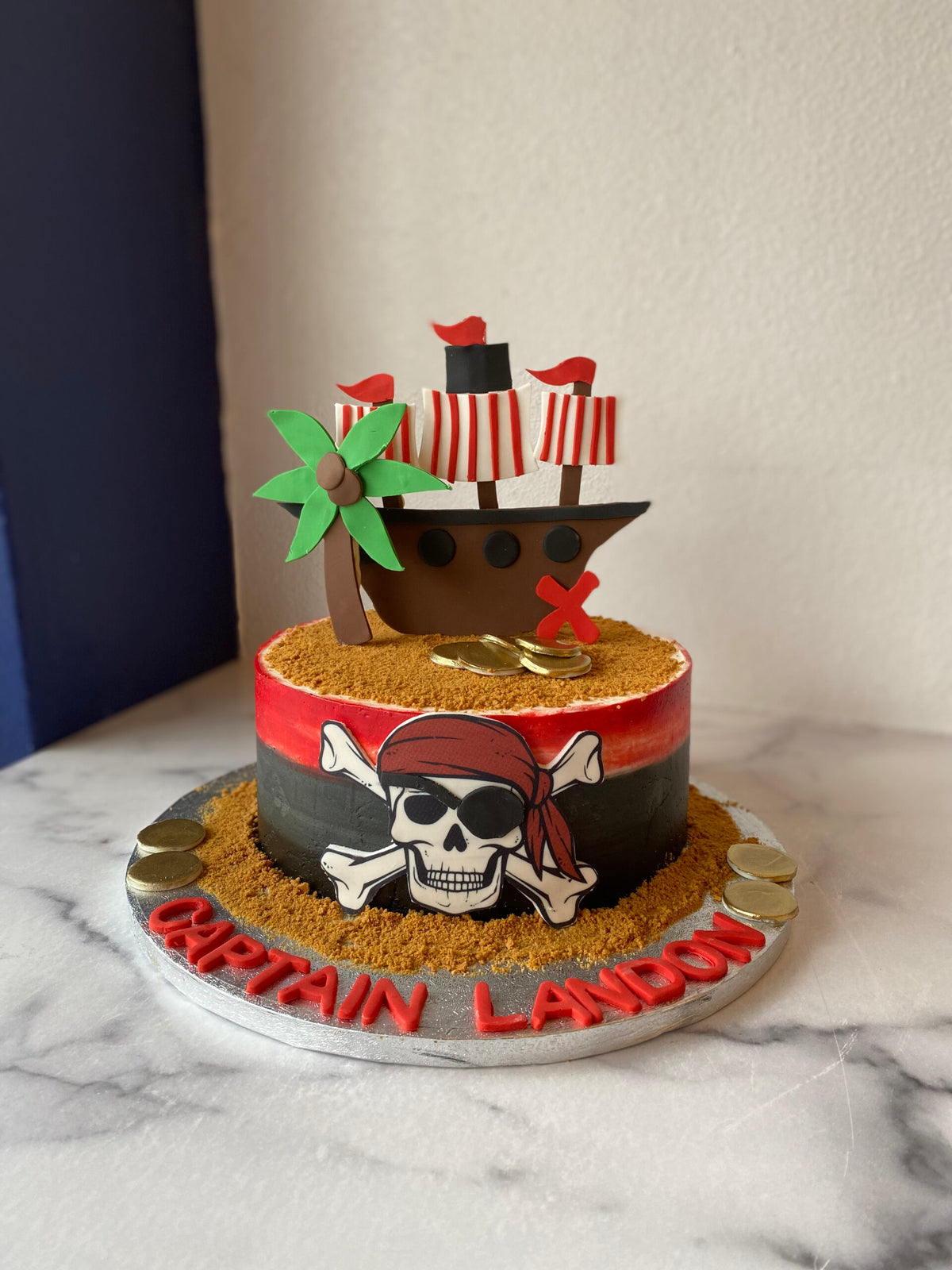 Pirate-themed birthday cake with fondant ship and treasure details