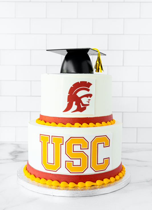 Two-tier graduation cake decorated with a customer's chosen school colors and logo