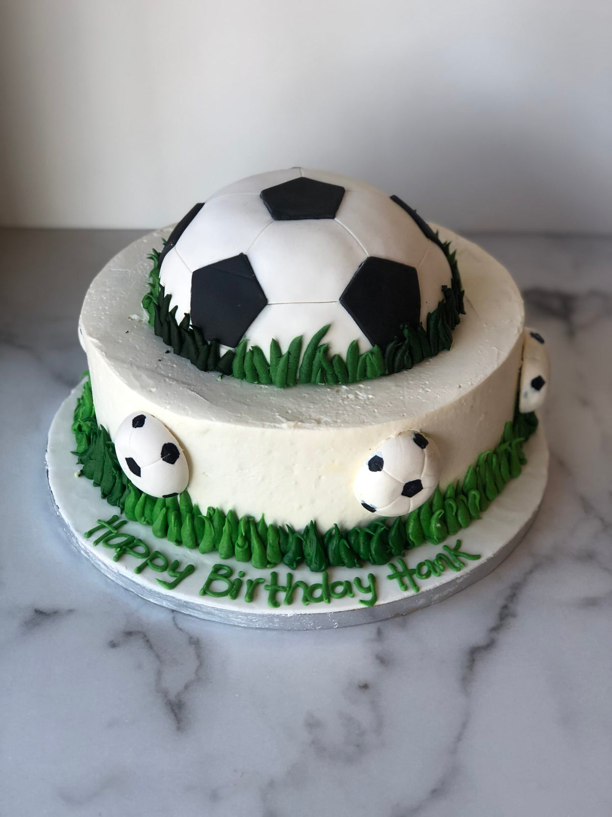 Soccer-themed birthday cake decorated with a fondant soccer ball