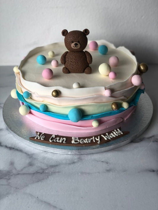 Baby shower cake with a teddy bear theme and "We Can Bearly Wait" design