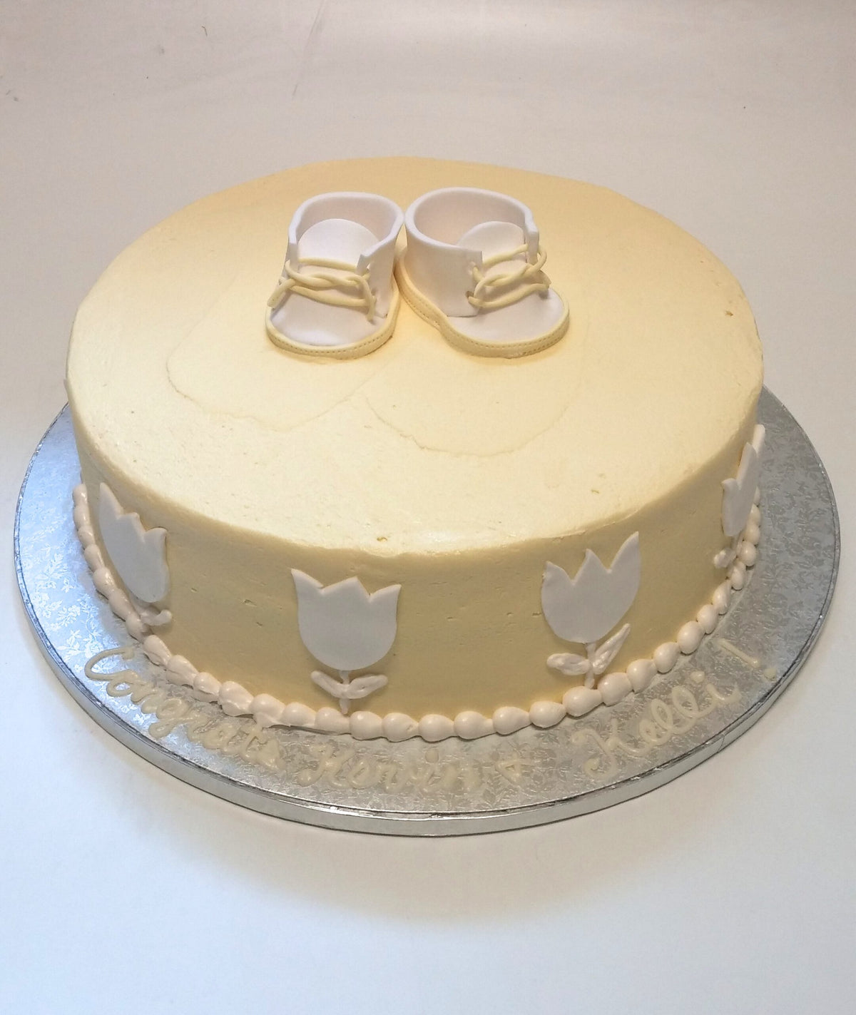 Baby shower cake decorated with yellow baby shoes