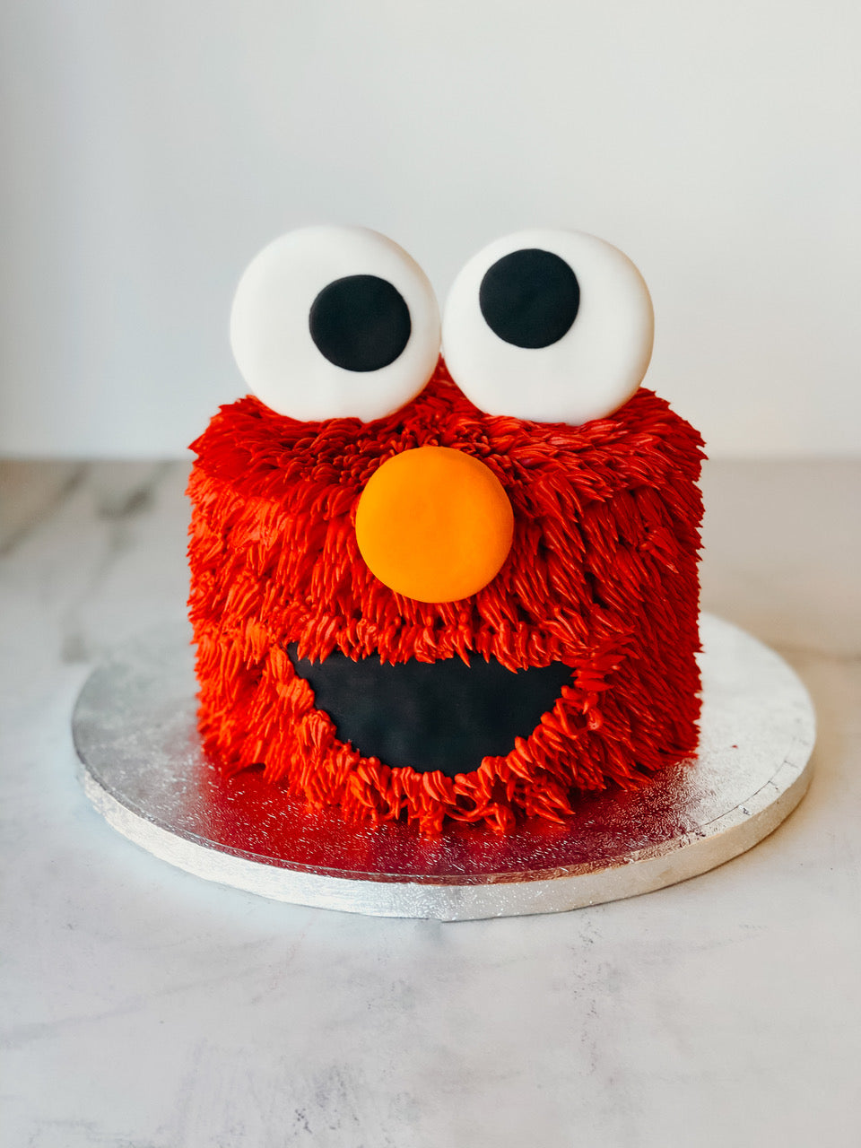 Sesame Street Elmo birthday cake with a sculpted character topper