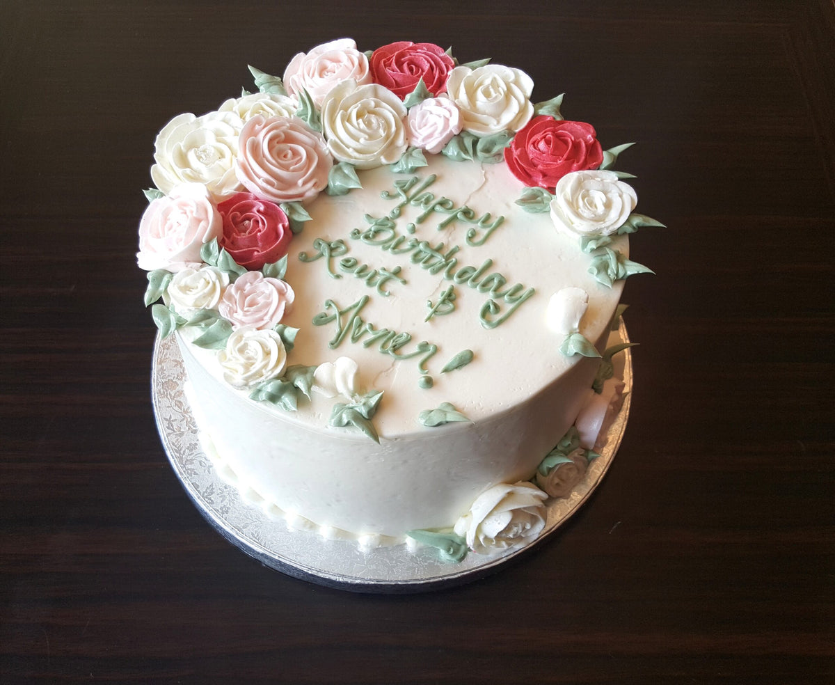 Cake decorated with roses along half of the top rim