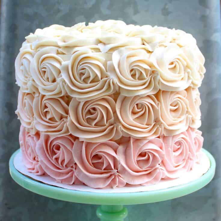 Cake covered in rosette piping in an ombre color gradient