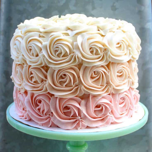 Cake covered in rosette piping in an ombre color gradient