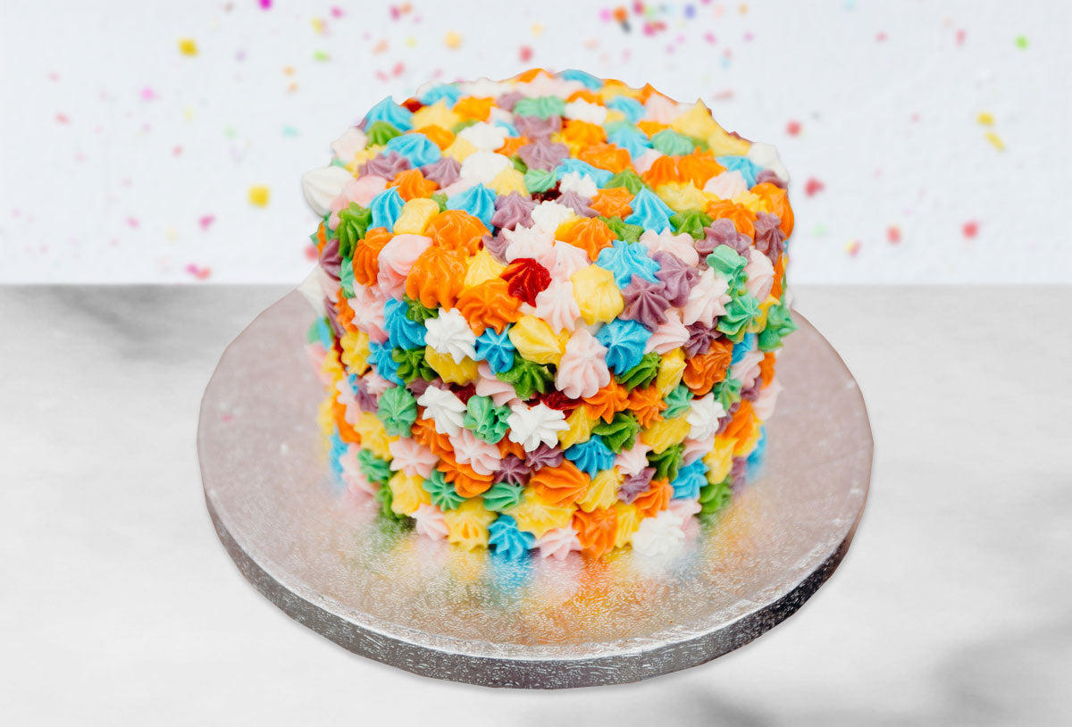 Cake decorated with colorful rainbow-striped frosting kisses